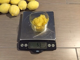 Glass of lemon zest on a food scale.